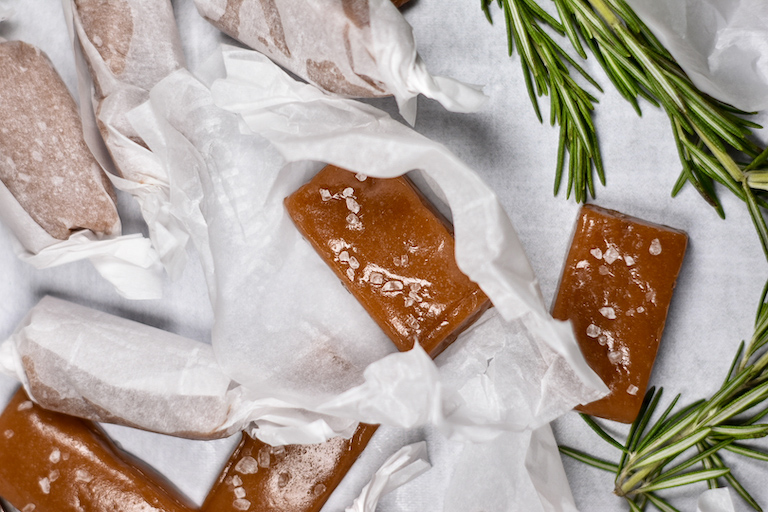 Rectangle shaped rosemary sea salt caramels and white parchment wrappers
