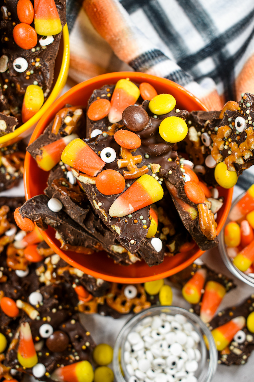 Bowls of chocolate bark along with bowls of candy corn and candy eyeballs