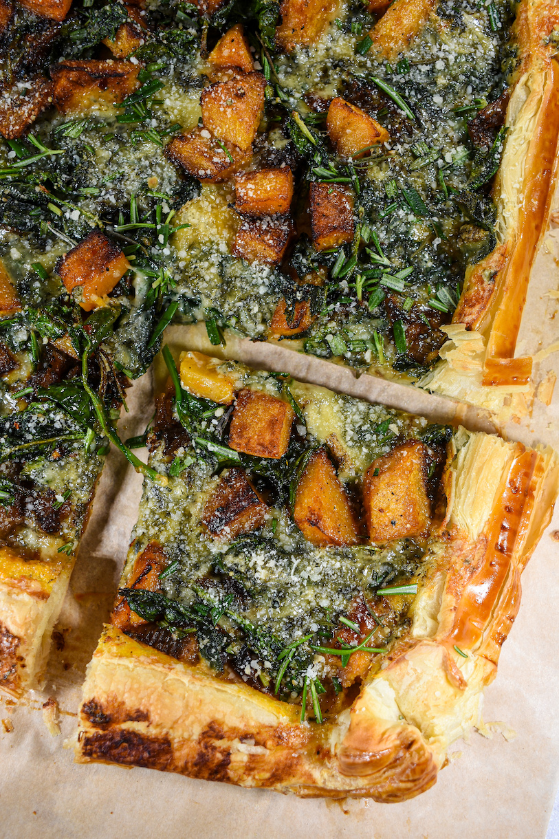 A square portion of puff pastry tart on a sheet of parchment