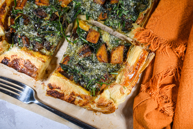Squares of butternut squash tart with an orange tea towel