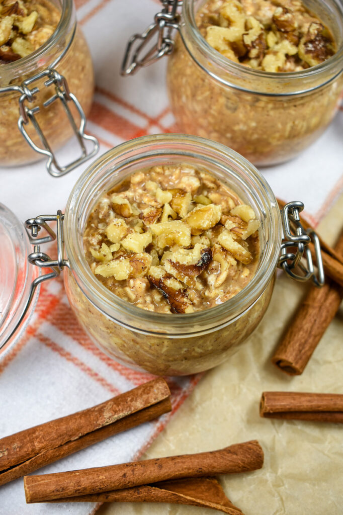 jar of pumpkin overnight oats surrounded by cinnamon sticks