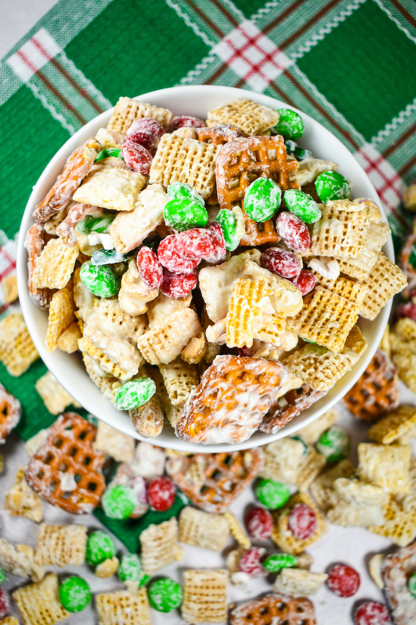 looking down at a bowl of Christmas Chex mix on a green towel
