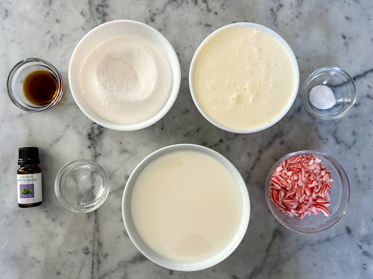 Ingredients for making homemade peppermint stick ice cream arranged on a marble surface