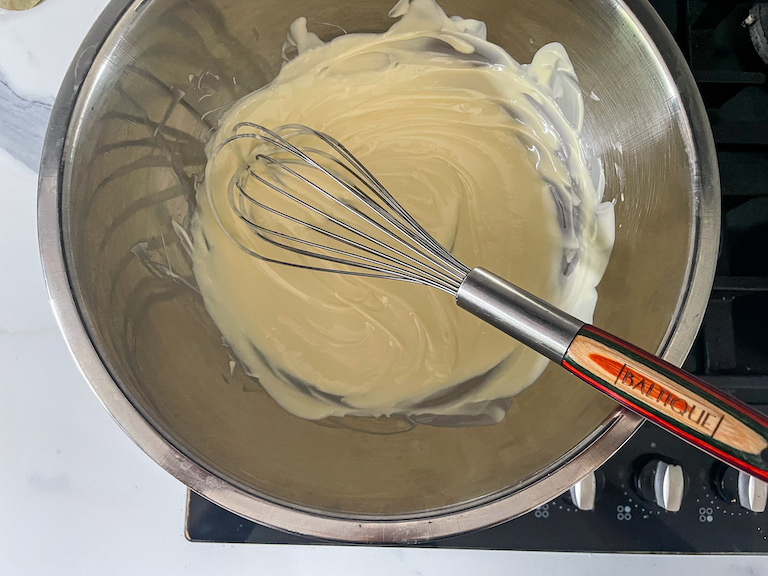 Melted white chocolate in a bowl on the stovetop