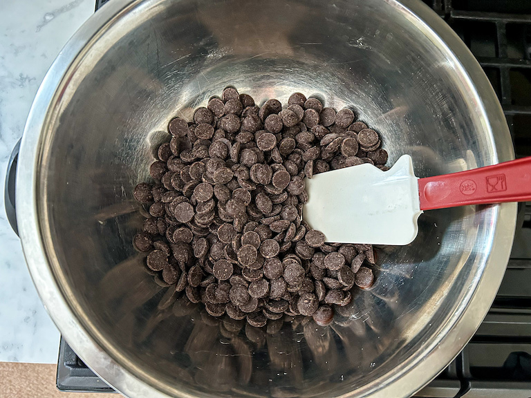 Chocolate chips in a bowl with a spatula