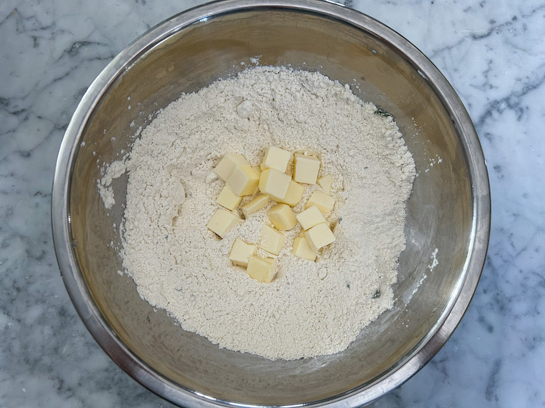 Flour and butter cubes in a metal bowl
