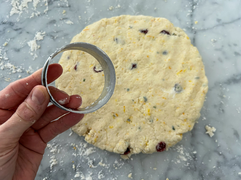 Hand holding a round metal cutter