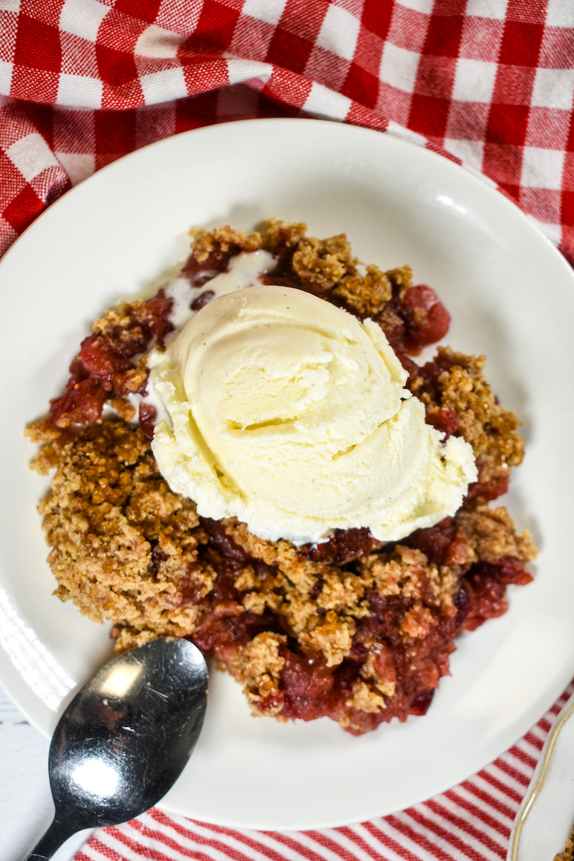 cranberry apple crumble topped with a scoop of vanilla ice cream