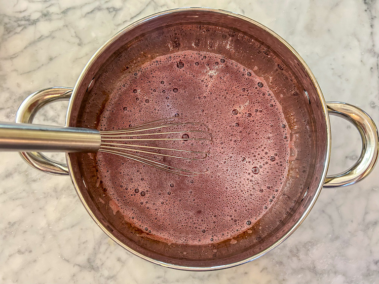 Cranberry candy mixture in a pan with a whisk