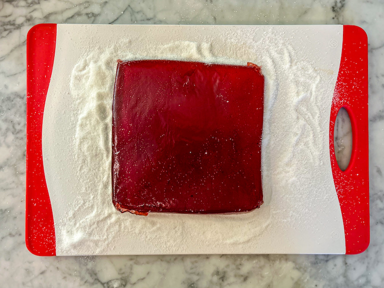 Cranberry jelly candy slab on a sugar coated cutting board