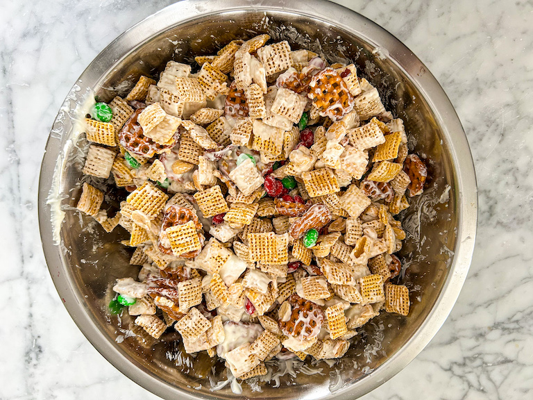 Bowl of Christmas Chex mix on a marble countertop
