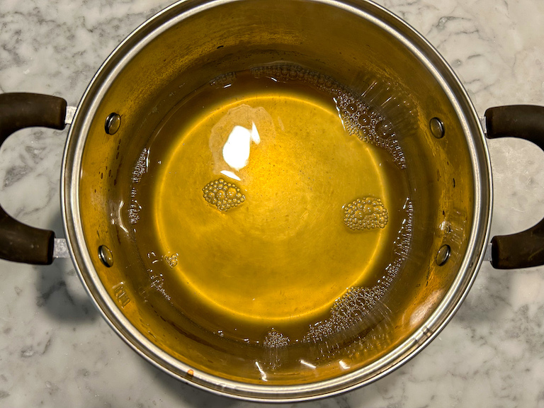 White wine mulled wine in a pot on a marble countertop