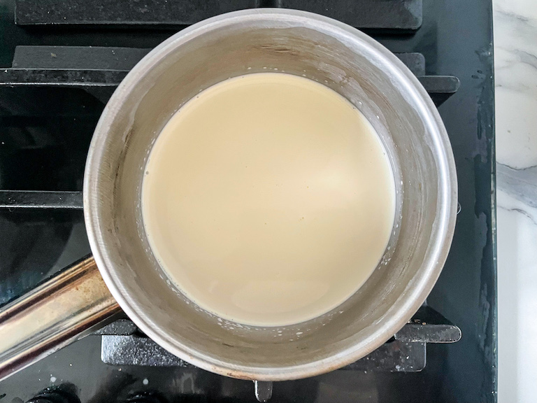 A small pan of cream on the stovetop