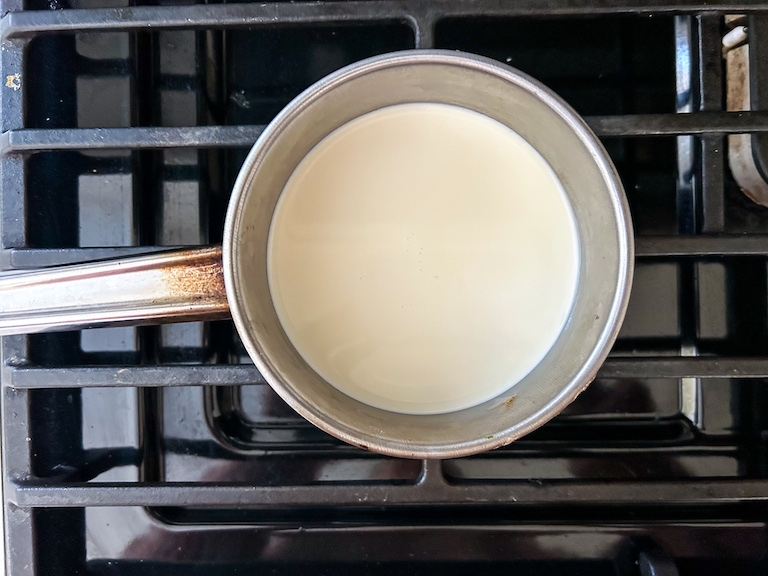 A small pan of cream on the stovetop