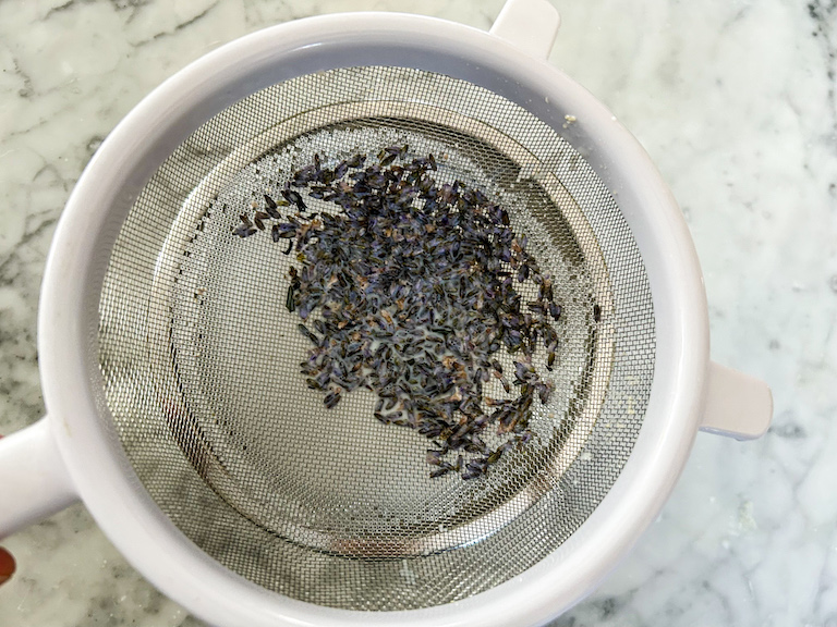 Passing lavender through a fine mesh strainer