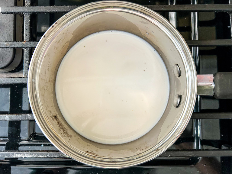 A saucepan of lavender infused milk on the stovetop