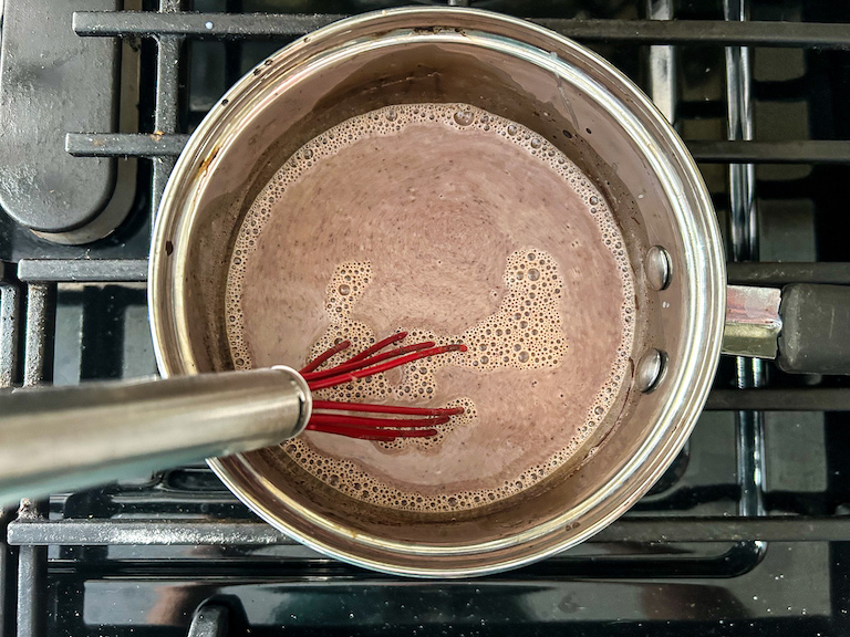 Whisking chocolate into a pan of warm milk