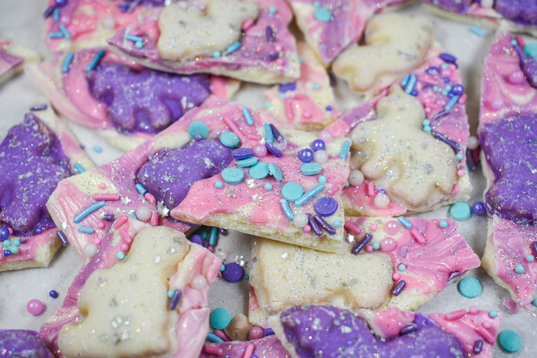 Pieces of unicorn candy bark on a white surface
