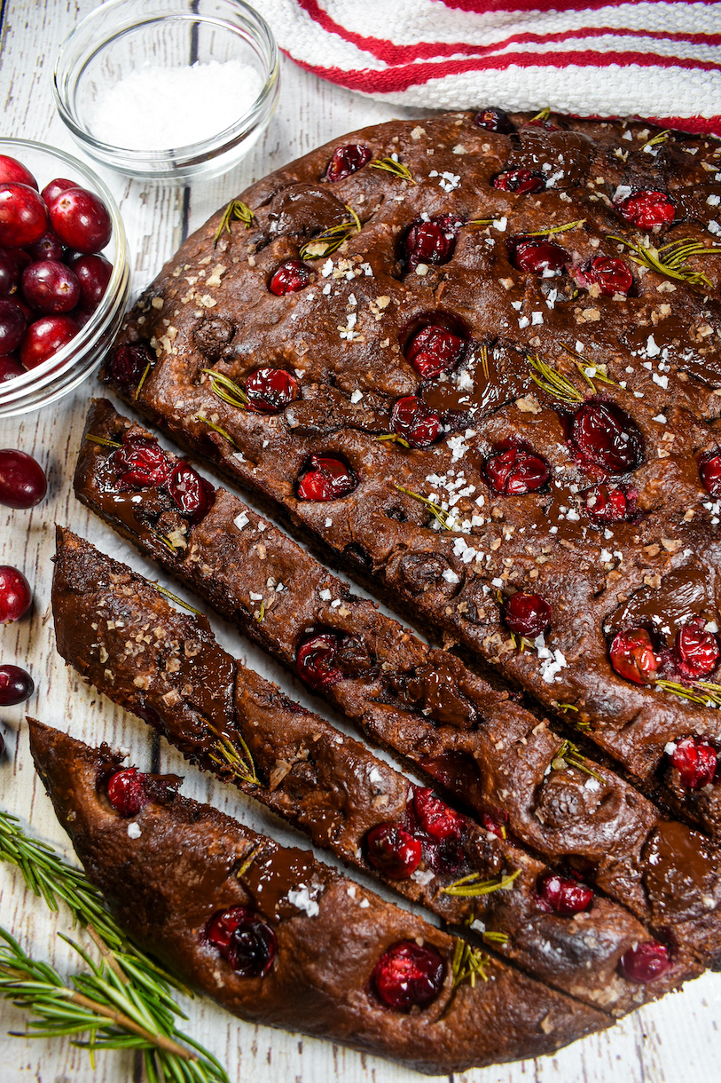 sliced chocolate cranberry focaccia on a white surface
