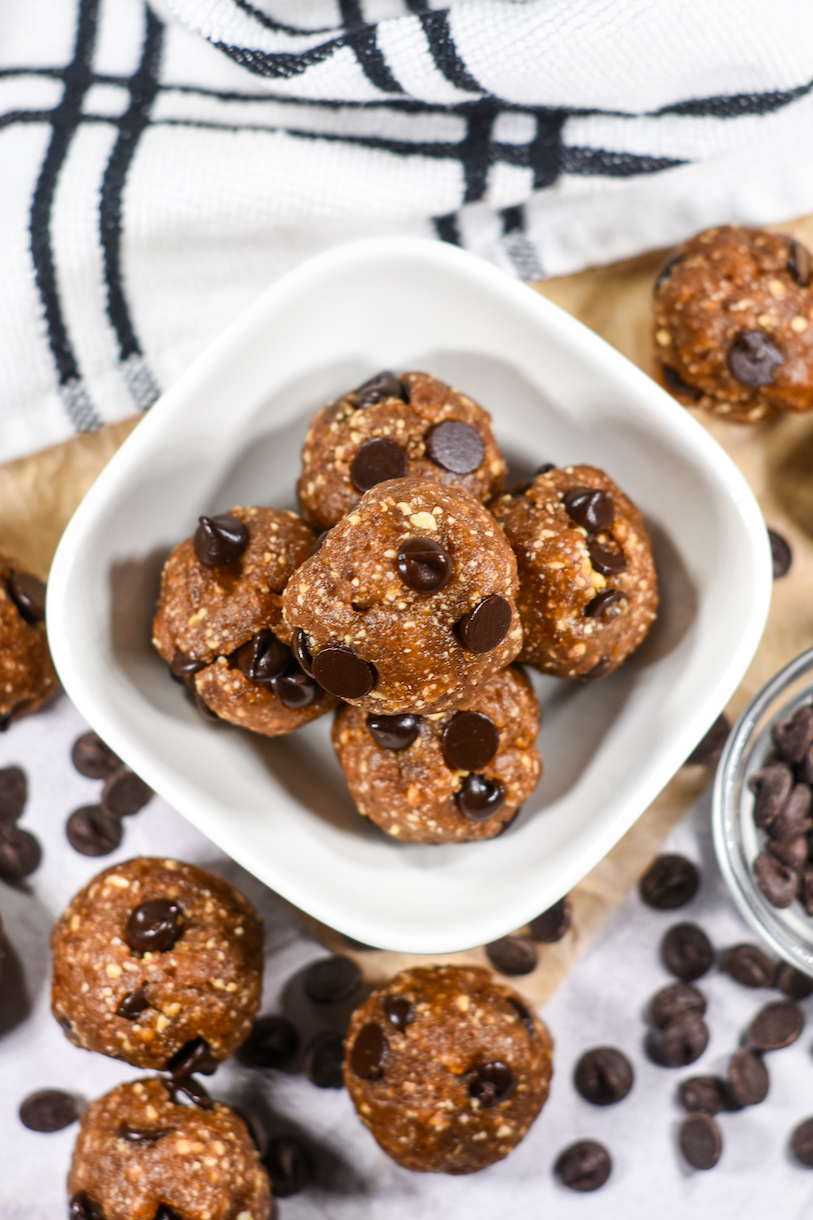 Looking down at a bowl of date chocolate chip balls and a plaid tea towel