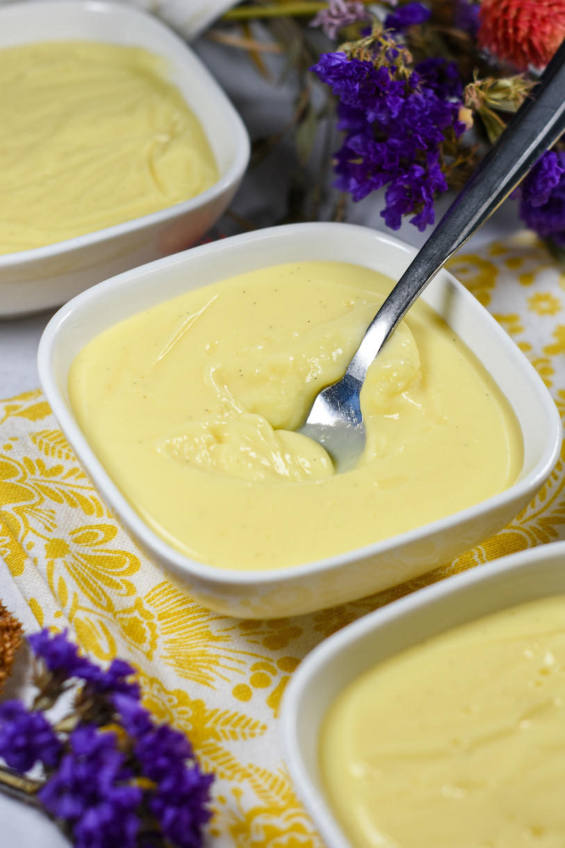 a dish of vanilla pudding on a yellow floral print towel