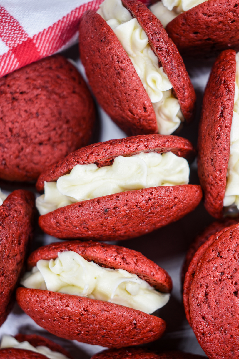 Red velvet mini whoopie pies arranged on a white surface