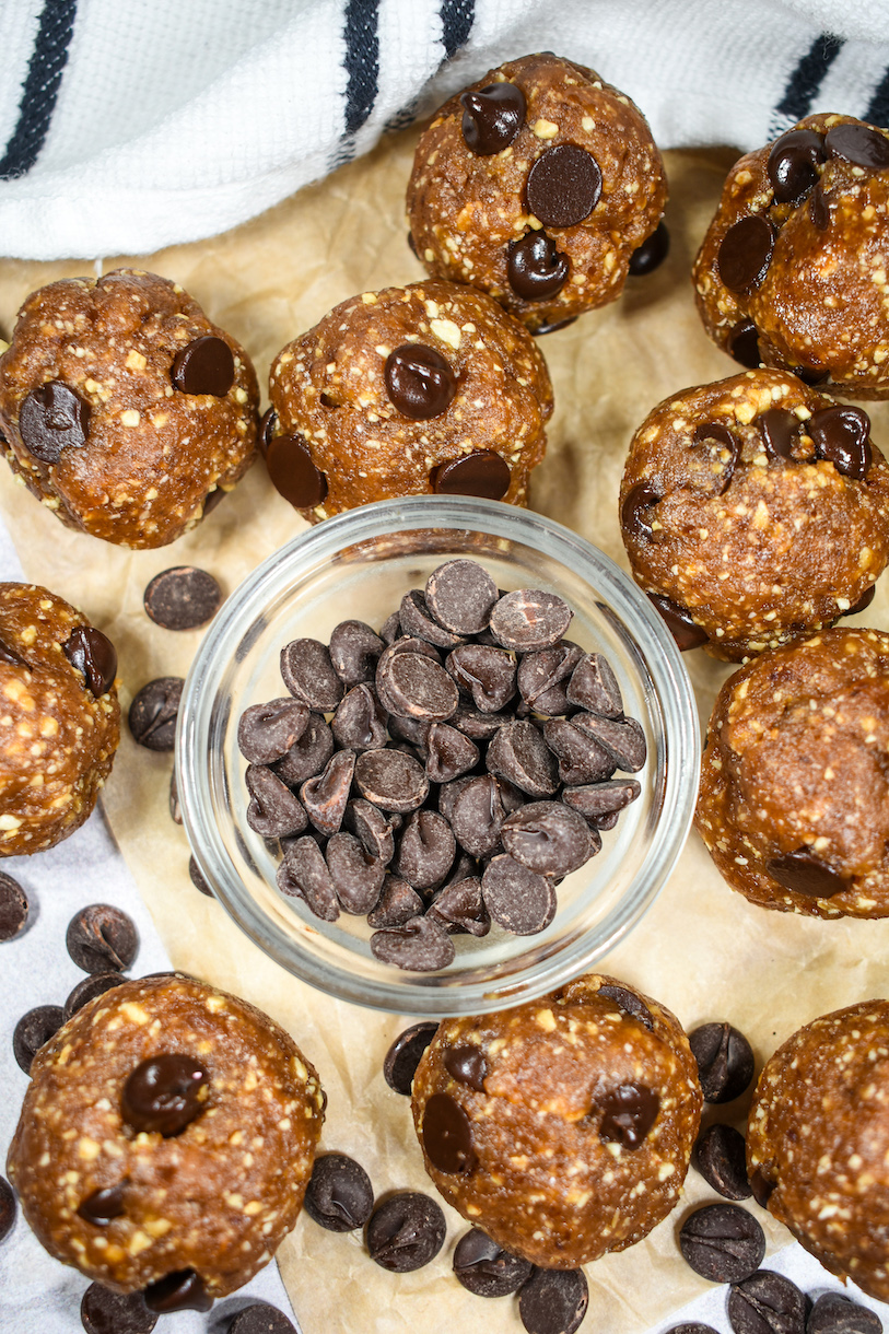A bowl of chocolate chips surrounded by cookie dough date balls