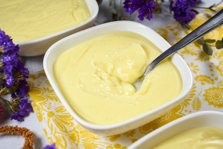 A dish of vanilla pudding with a spoon