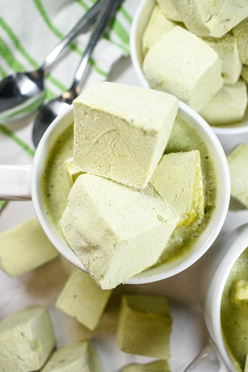 A mug of matcha hot chocolate garnished with matcha marshmallows