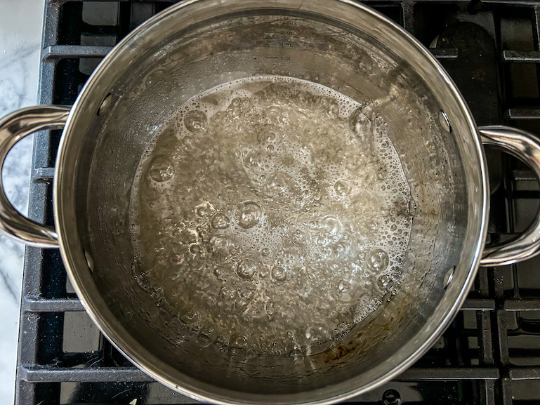 Corn syrup, water, and sugar bubbling in a stock pot on the stovetop