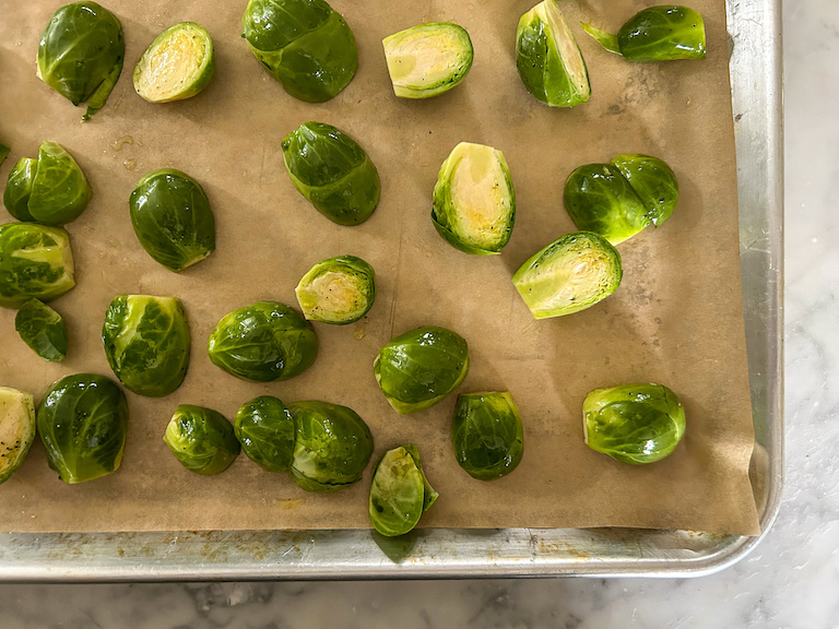 Sliced sprouts arranged on a parchment lined tray