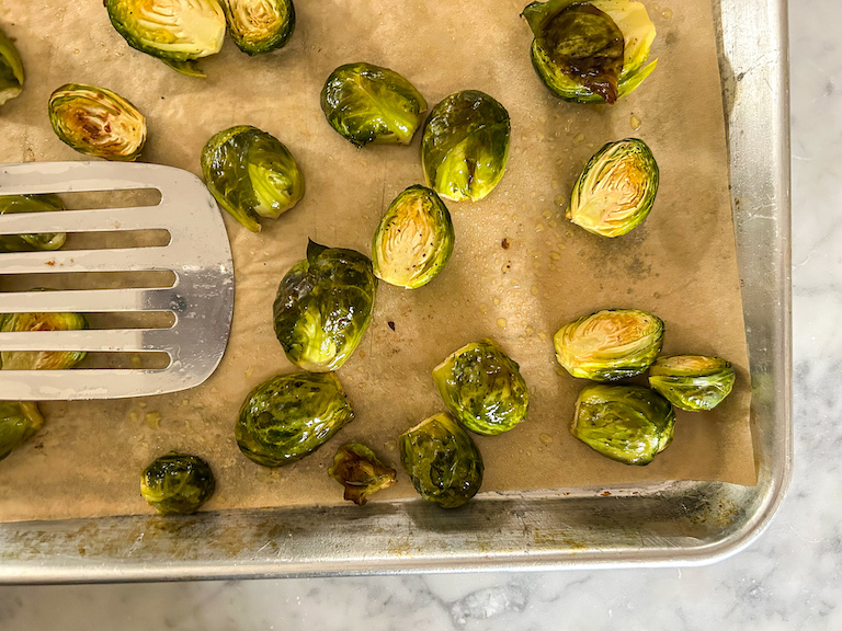 Spatula tossing Brussels sprouts as they roast