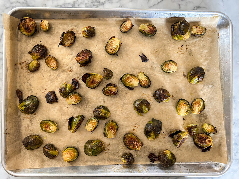Roasted brussels sprouts on a parchment lined tray