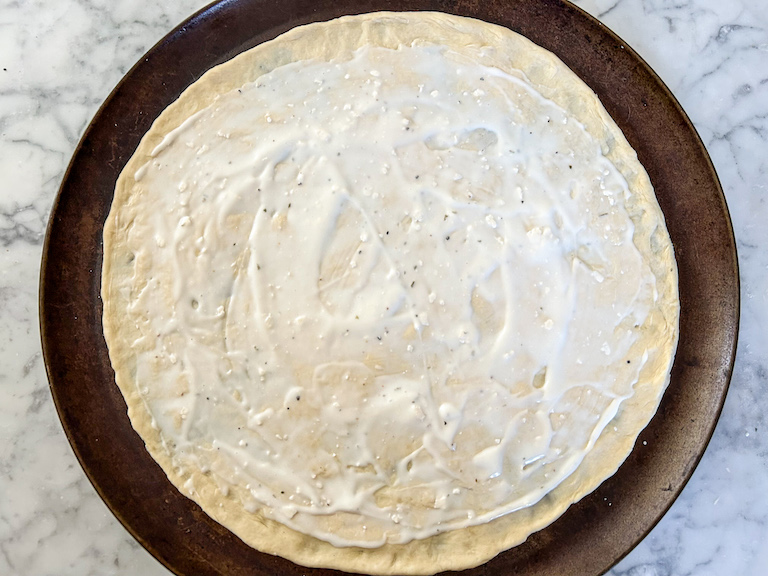 Pizza dough spread with blue cheese dressing