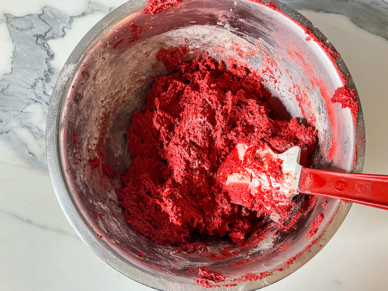 Red velvet whoopie pie batter in a bowl with a spatula