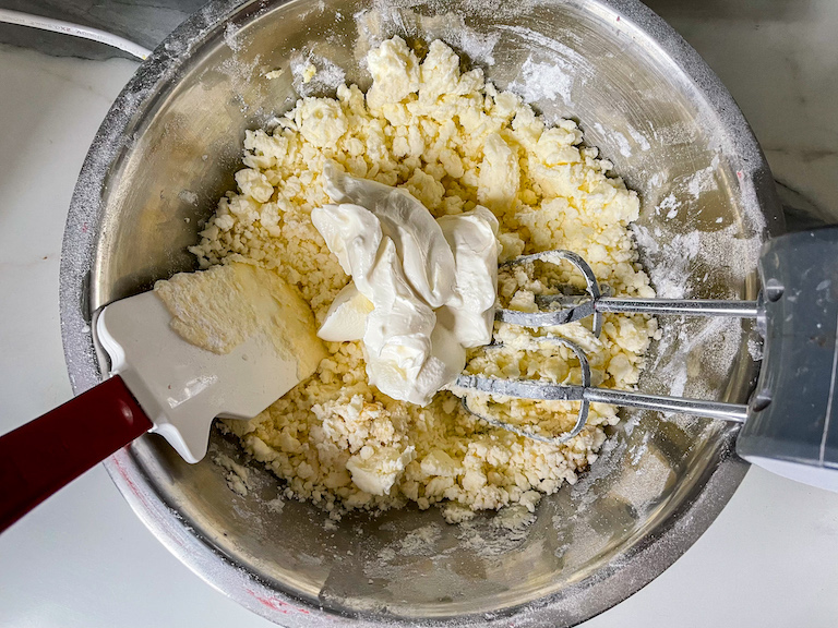 Combining cream cheese frosting ingredients in a bowl