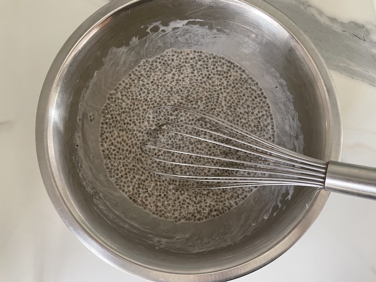 Chia pudding ingredients in a bowl with a whisk