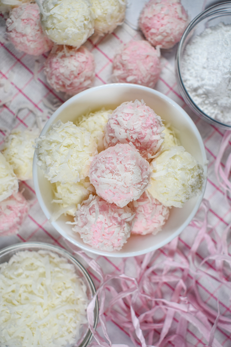A bowl of pink and white truffles on a plaid towel