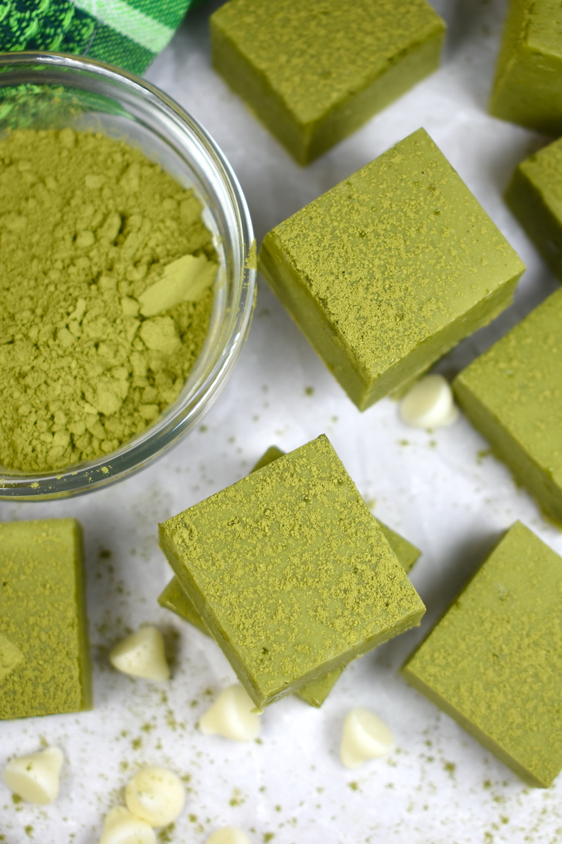 Matcha fudge and a dish of culinary matcha powder on a white surface