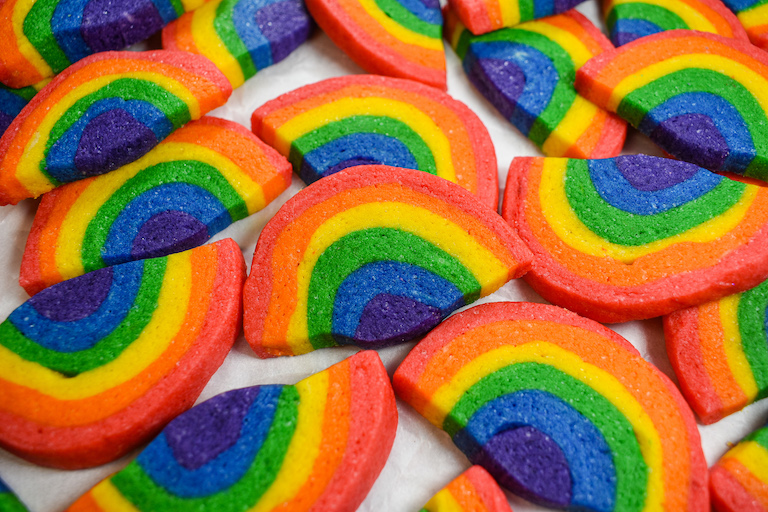 Rainbow shaped sugar cookies on a white surface