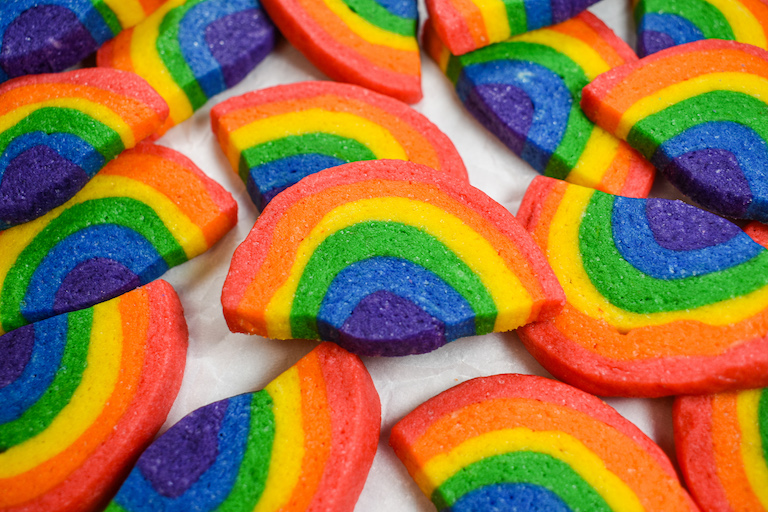 Rainbow cookies arranged on a white surface