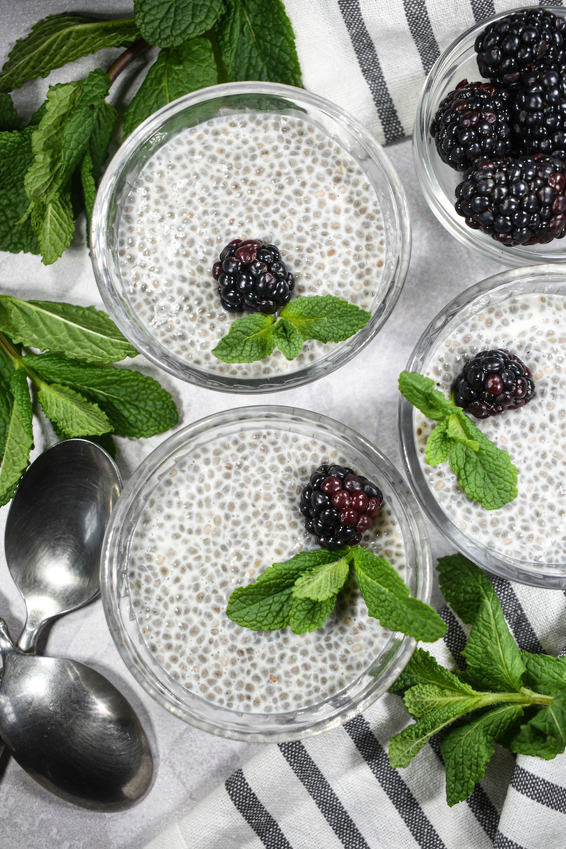 Three dishes of almond milk chia seed pudding garnished with blackberries and mint