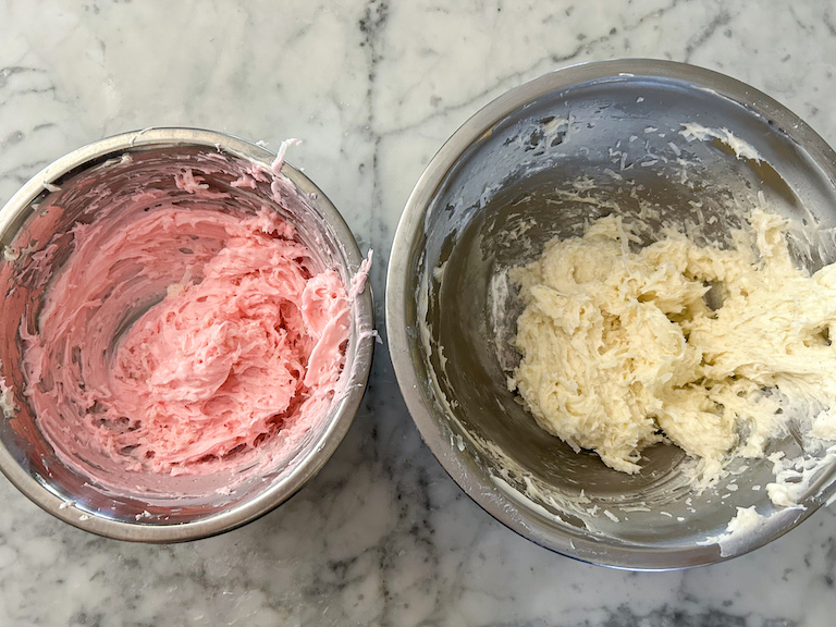 Pink and white Easter truffle dough in metal bowls on a countertop