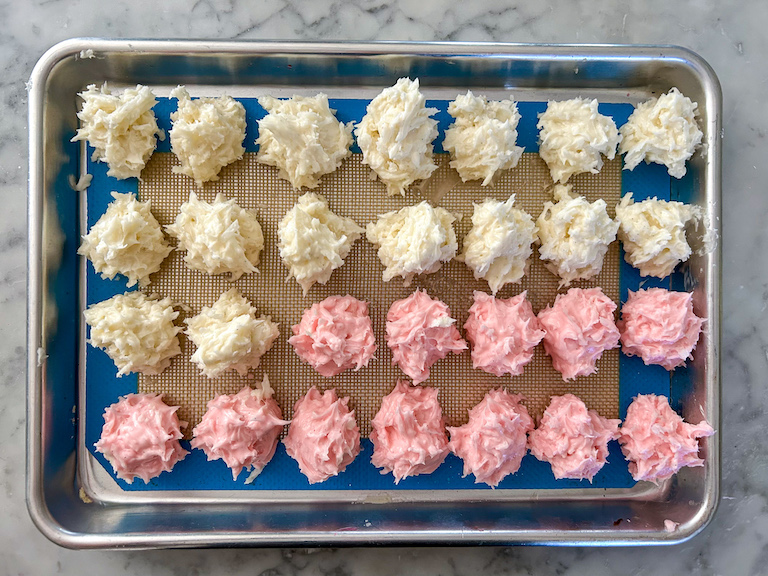 Pink and white truffle dough scooped into mounds on a small tray