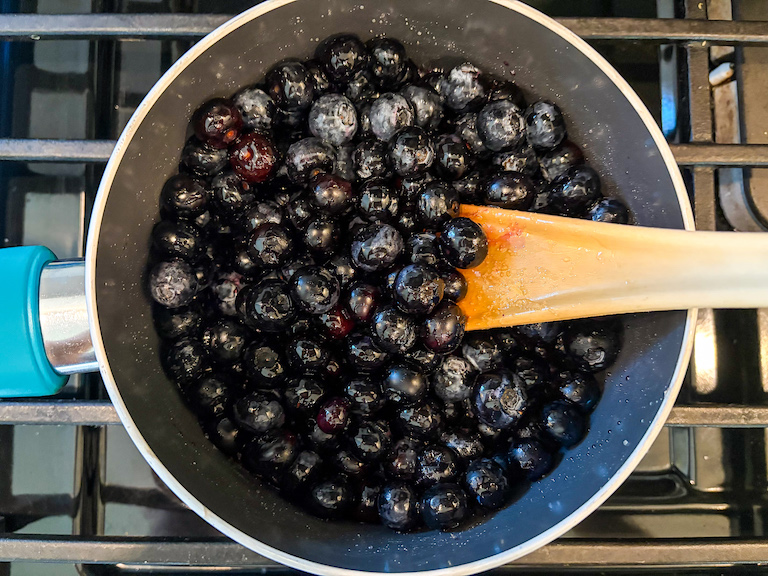 Blueberries and sugar in a pan on the stovetop