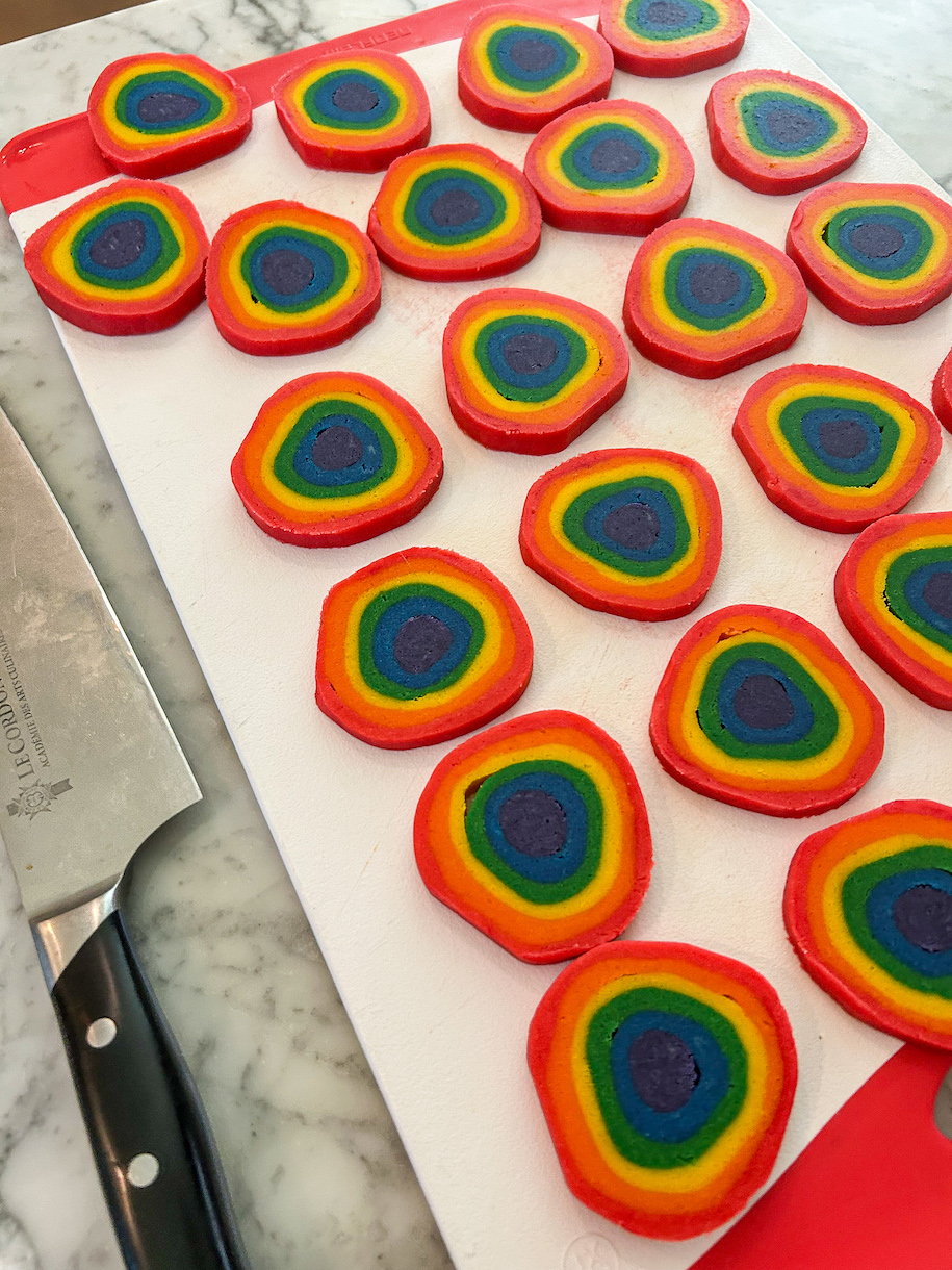 Slices of rainbow cookie dough on a cutting board