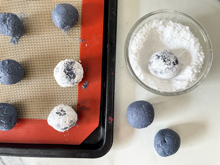 Rolling chocolate truffles in confectioner's sugar