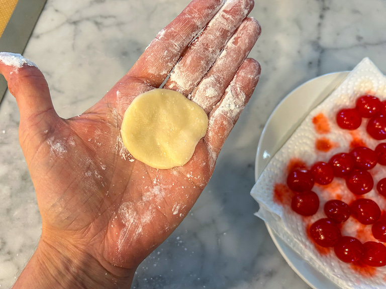A flattened piece of fondant in the palm of a hand