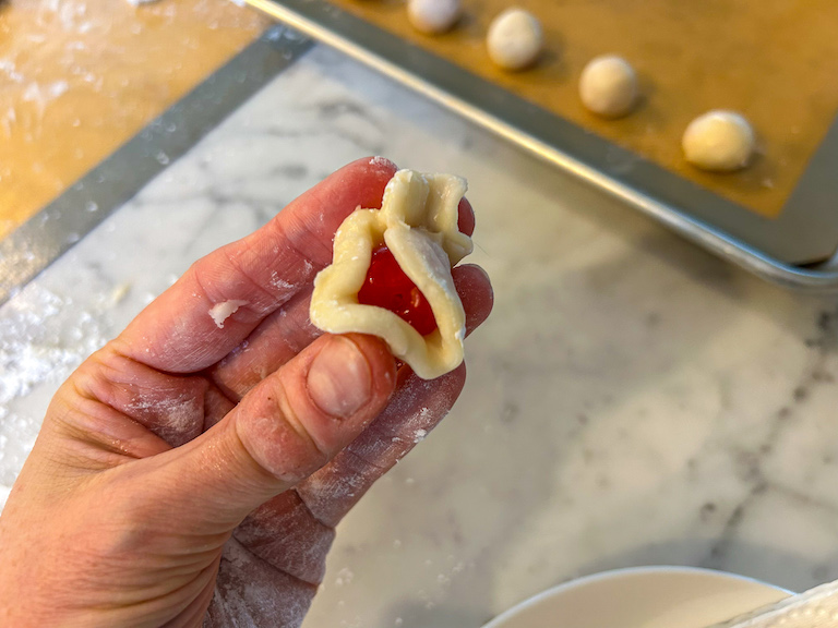 Hand wrapping fondant around a cherry