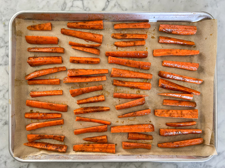 Carrot sticks arranged on a parchment lined tray